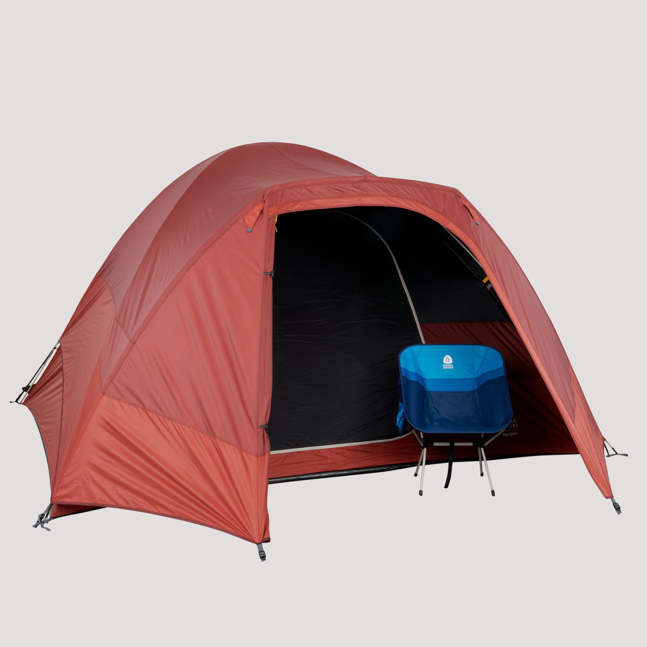 Sierra Designs Alpenglow 6 tent, shown with fly attached, door open, with chair