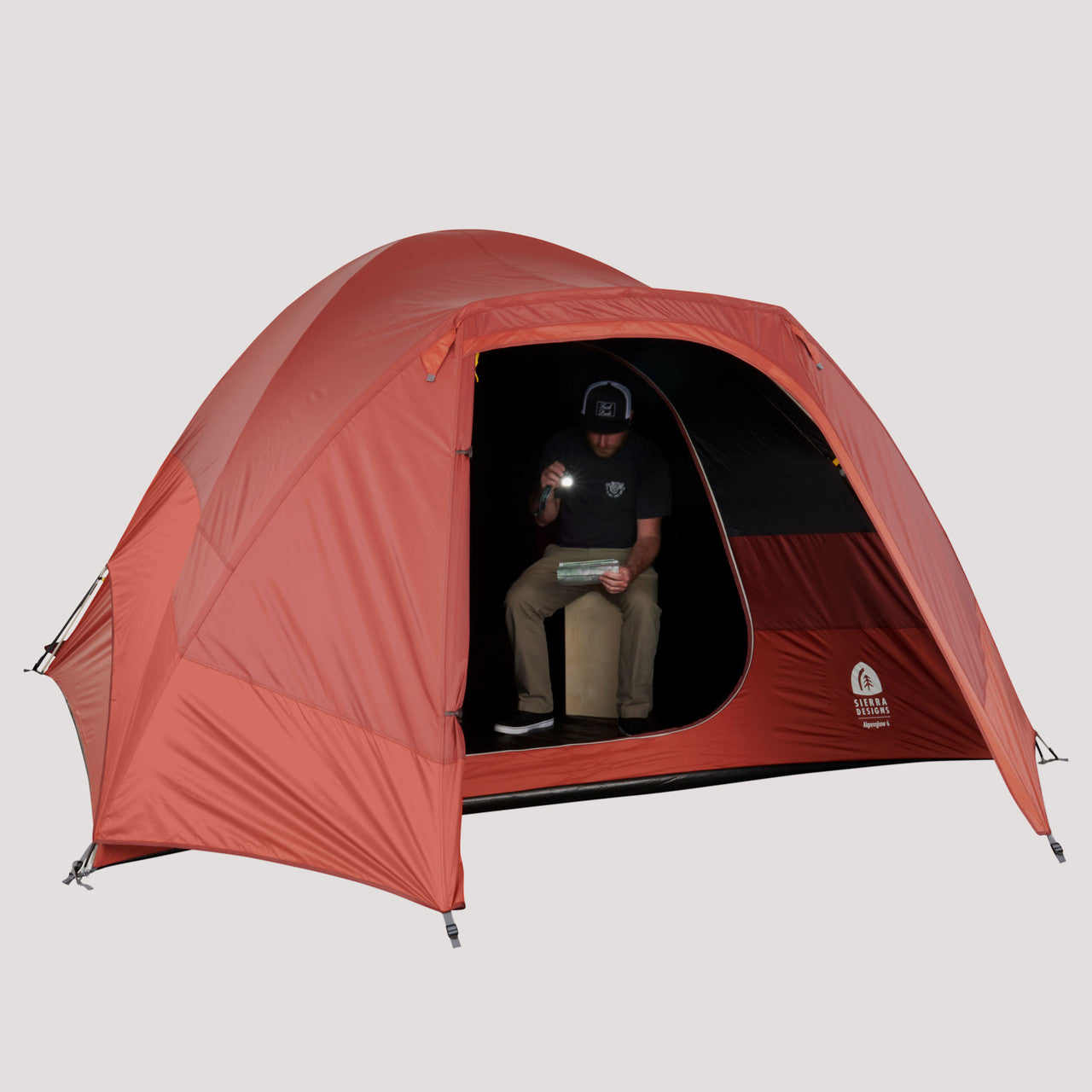Sierra Designs Alpenglow 6 tent, shown with fly attached, door open, with man in tent