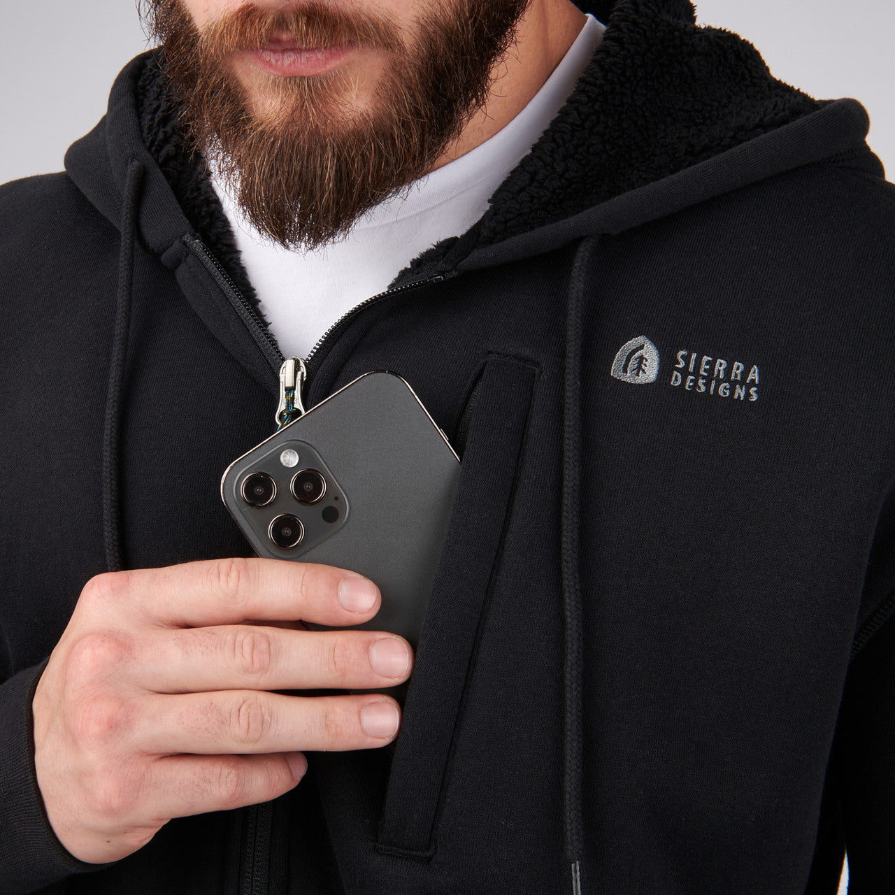 Close up of man wearing Sierra Designs Men's Angora Hoodie, putting phone in pocket