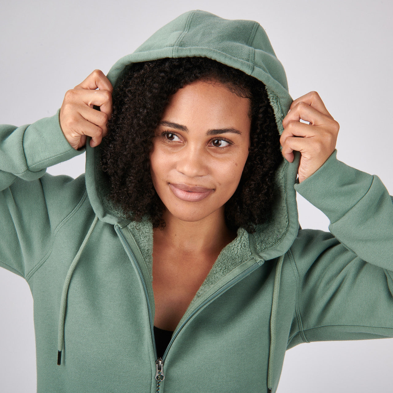 Close up of woman wearing Sierra Designs Women's Angora Hoodie, adjusting hood