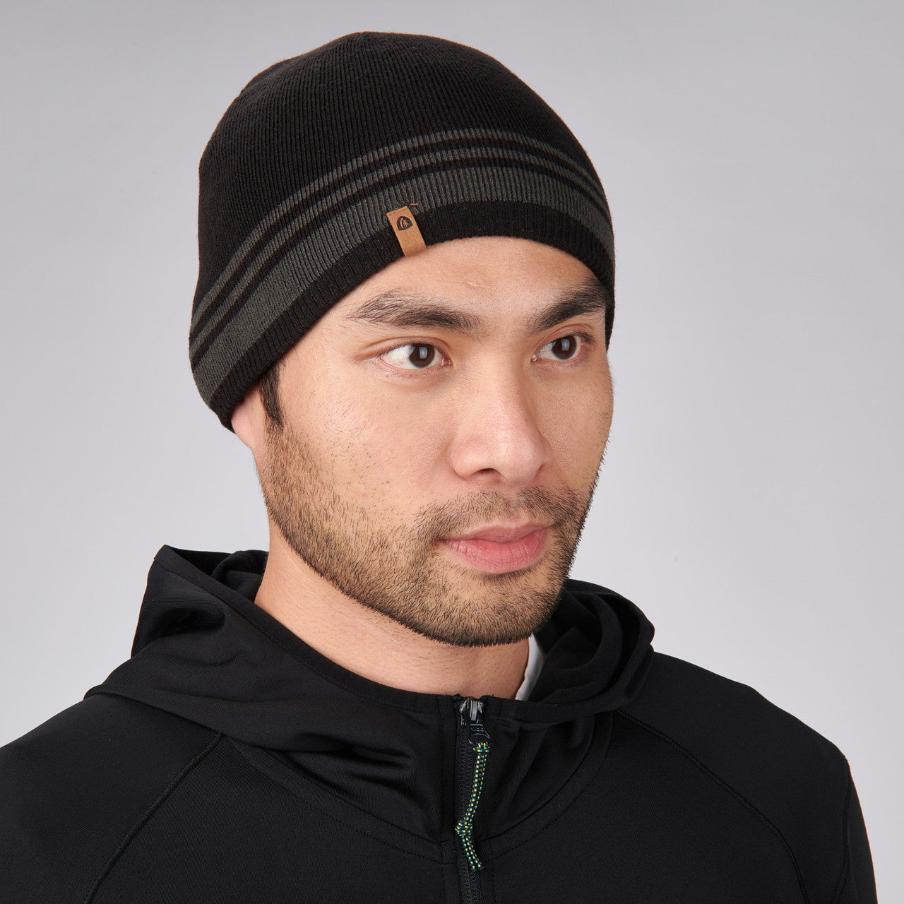Man wearing Sierra Designs Cleo Reversible Beanie, Black / Gun Metal
