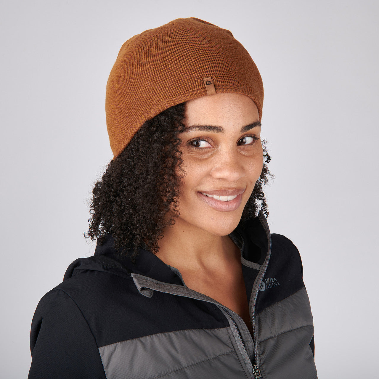 Woman wearing Sierra Designs Cleo Reversible Beanie, Dijon / Cornstalk