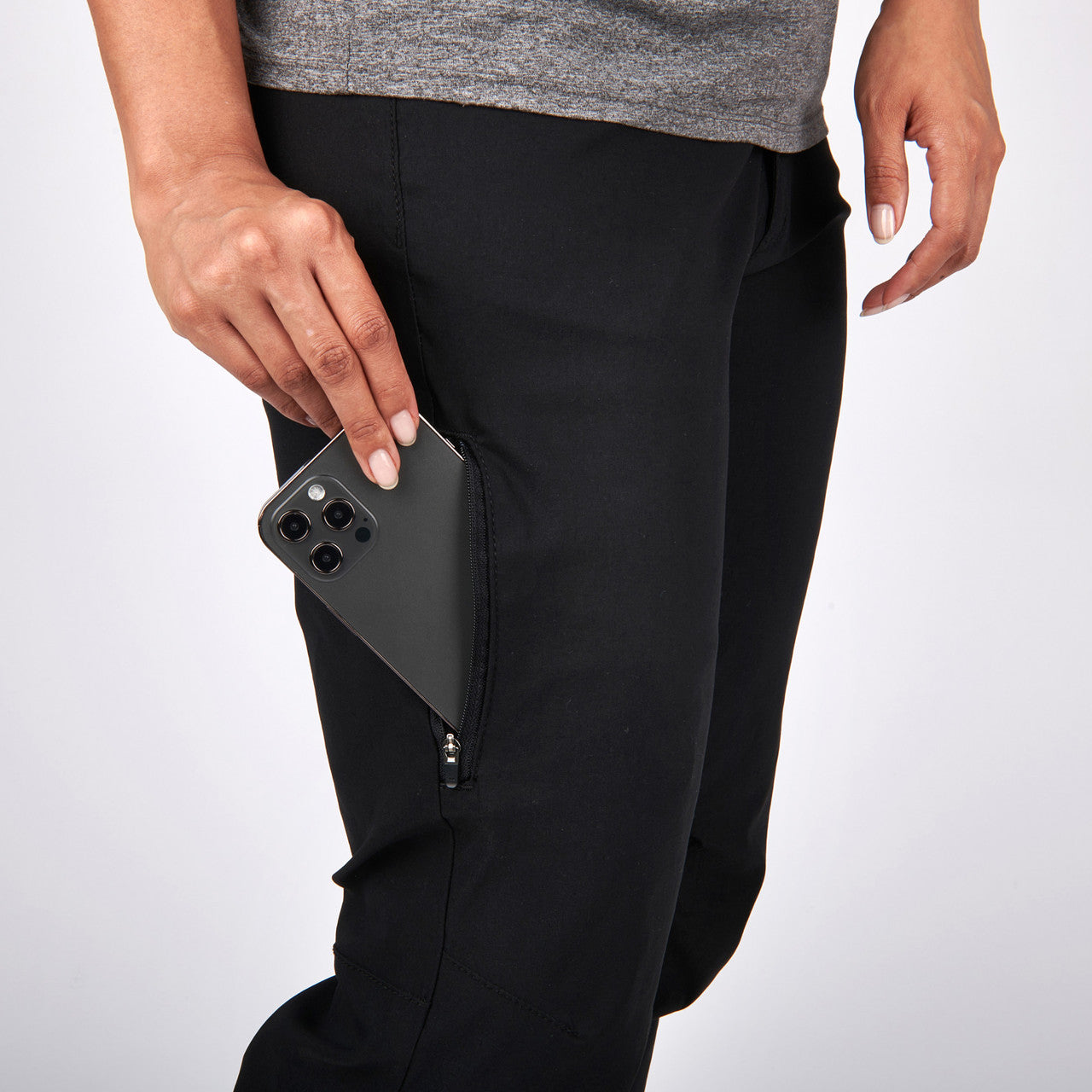 Close up of woman wearing Sierra Designs Women's Inyo Stretch Pant, putting phone in pocket