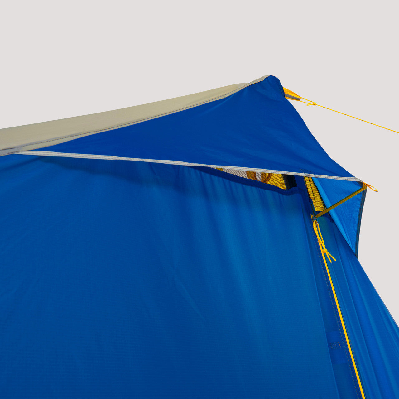 Close up view of the top of the Sierra Designs High Route 1 FL showing the main door zipper, a vent, and a guy line