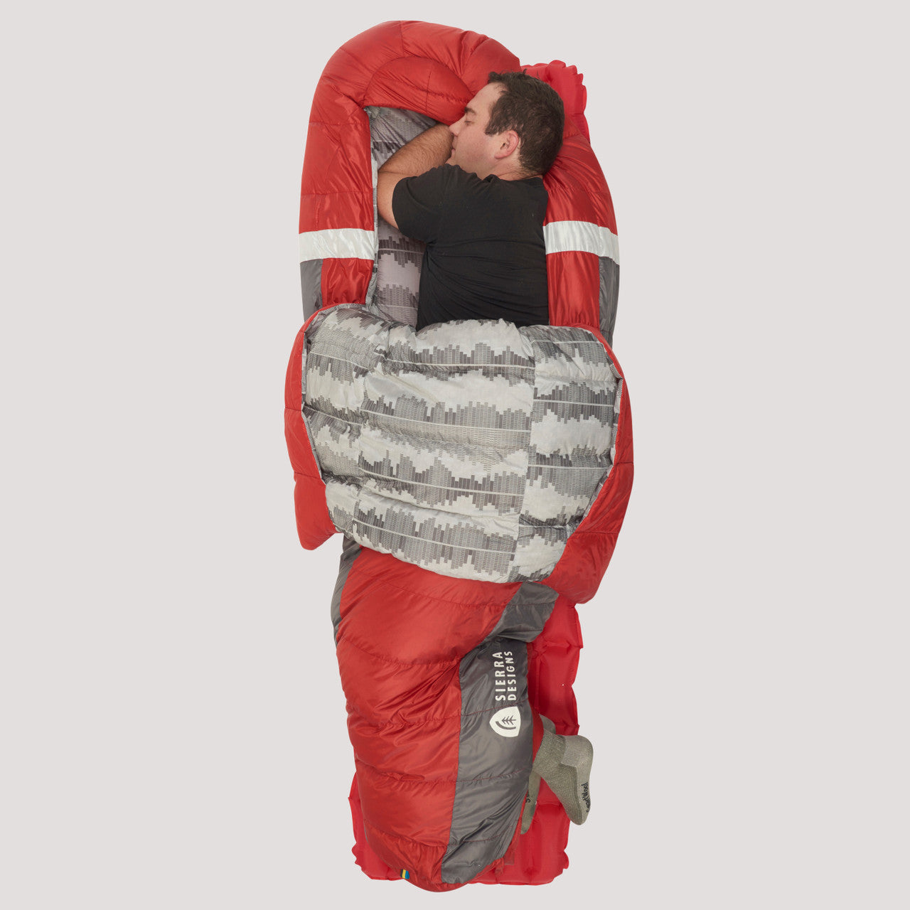 Man sleeping on his side in Sierra Designs Backcountry Bed 650 / 20 Degree sleeping bag, with bag opened