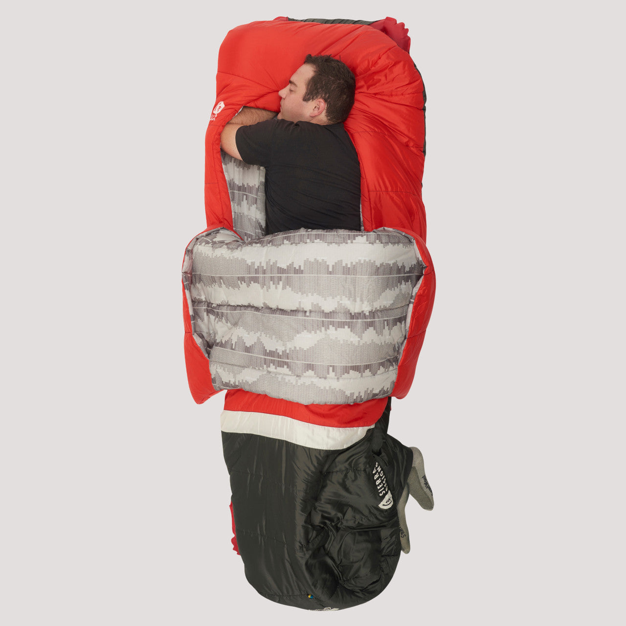 Man sleeping on his side in Sierra Designs Frontcountry Bed 20, with integrated comforter pulled out